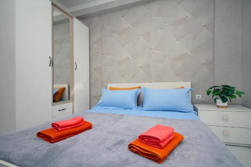 a bedroom with a bed with two towels on it at Жулдыз рядом с Аэропортом in Almaty