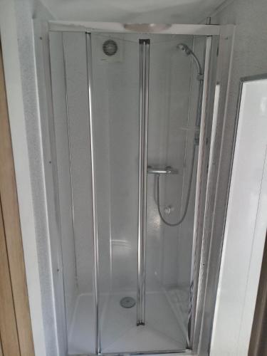 a shower with a glass door in a bathroom at Alocin cottage in Melmerby
