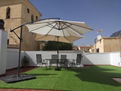 a patio with a table and chairs and an umbrella at Casa Rural Almécija in Illar