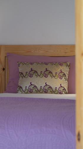 a bed with purple sheets and a pillow on it at Riad Al Manara in Essaouira