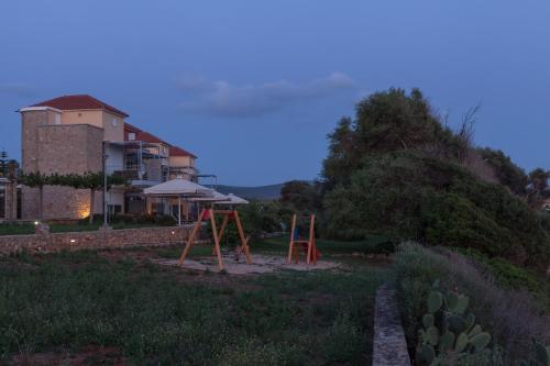 a playground in front of a house with a building at Dialiskari Villas in Marathopolis