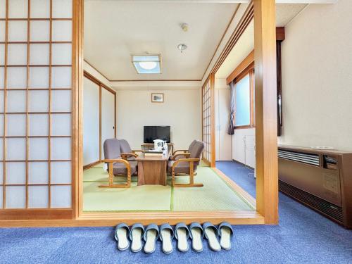 a mirror reflecting a room with a table and chairs at Hotel Sol at Lake Toya in Lake Toya