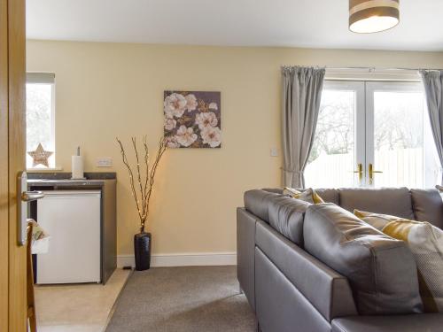 a living room with a couch and two windows at Two Dorchester Drive - Uk32036 in Inglewhite