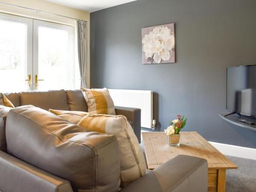 a living room with a leather couch and a table at Two Dorchester Drive - Uk32036 in Inglewhite