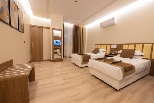 a hotel room with two beds and a couch at Sakura City Hotel in Al Baha