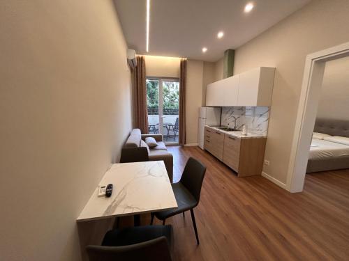 a room with a table and chairs and a bedroom at Molla Apartments Golem in Polisi i Vogël