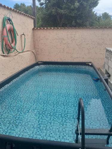 une piscine vide avec un tuyau sur un mur dans l'établissement Les Oliviers, à La Crau