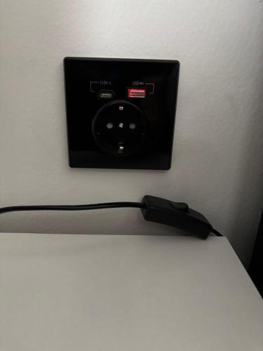 a black electrical outlet on a white wall at Avens in Burgrieden