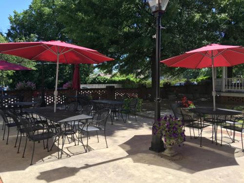 a group of tables and chairs with red umbrellas at Hale Springs Inn in Rogersville