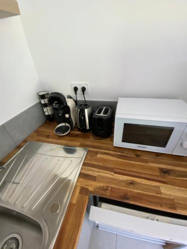 a kitchen with a counter top with a microwave at La grange du clos in Angiens