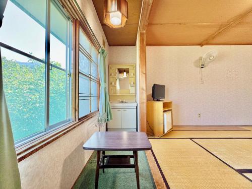 a room with a wooden table and a window at Hotel Sol at Lake Toya in Lake Toya