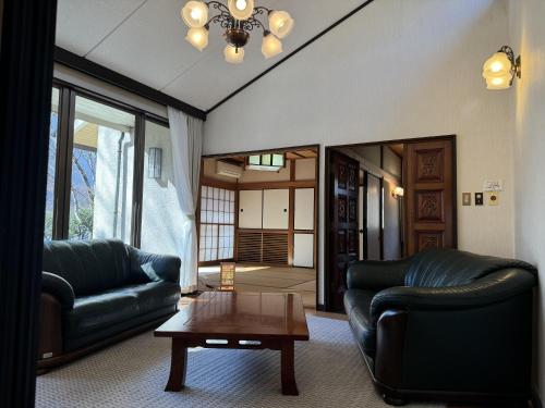a living room with two leather couches and a table at 楓リゾート鬼怒川温泉 优雅宽敞的日式独栋旅馆 in Nikko