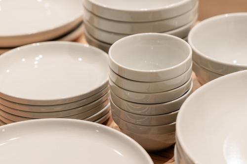 a pile of white plates sitting on a table at LUX by Hotel BAL in Fukuoka