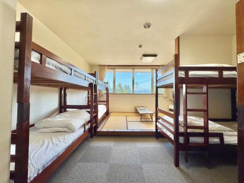 a room with three bunk beds and a window at Hotel Sol at Lake Toya in Lake Toya