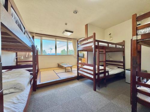 a room with two bunk beds and a balcony at Hotel Sol at Lake Toya in Lake Toya