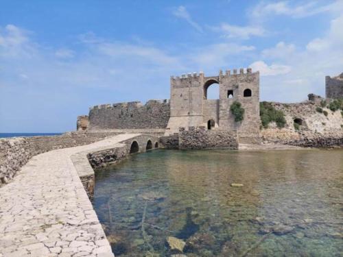 a castle with a bridge over a body of water at Villa in Finikounta near Sandy Beach in Finikounta