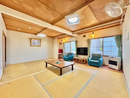 a living room with a table and chairs and a tv at Hotel Sol at Lake Toya in Lake Toya