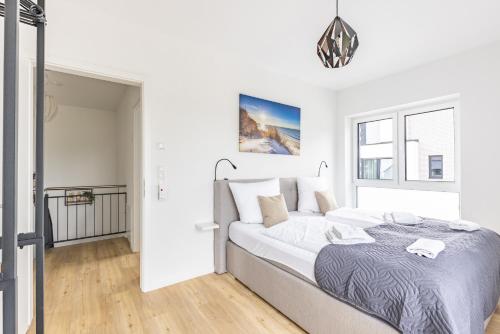 a white bedroom with a large bed in it at Das Strandhaus 2, mit Garten, 250 Meter zum See in Lembruch