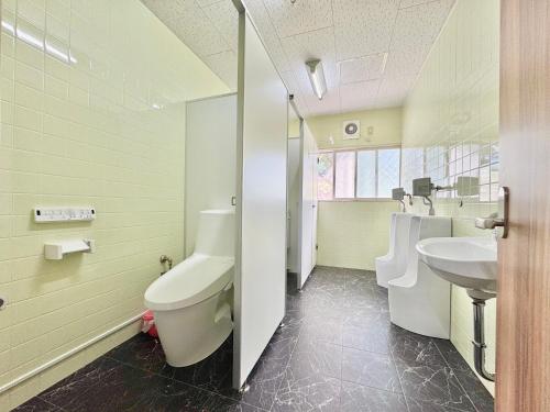 a bathroom with two urinals and a sink and a toilet at Hotel Sol at Lake Toya in Lake Toya