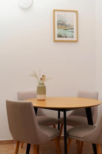 a dining room table with chairs and a vase on it at MonteHygge apartments in Tivat