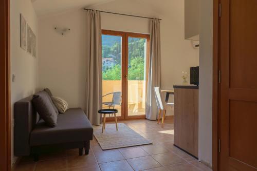 a living room with a couch and a table and a window at MonteHygge apartments in Tivat