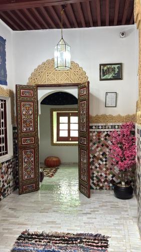 a room with an open doorway with a mirror and flowers at Riad Serendipity in Fès