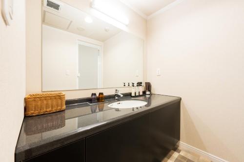 a bathroom with a sink and a large mirror at BeppuOnsen Hotel Sansenkaku in Beppu