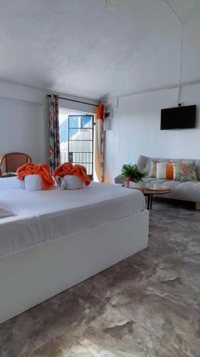 a bedroom with two white beds and a couch at Cocoon Paradise in Flic-en-Flac