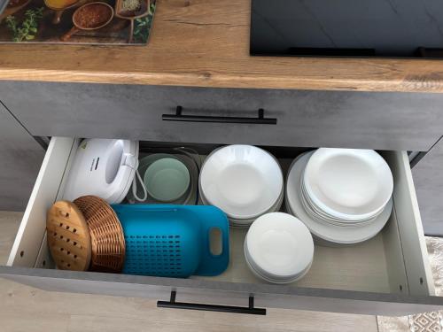 a drawer filled with white plates and bowls at Avens in Burgrieden
