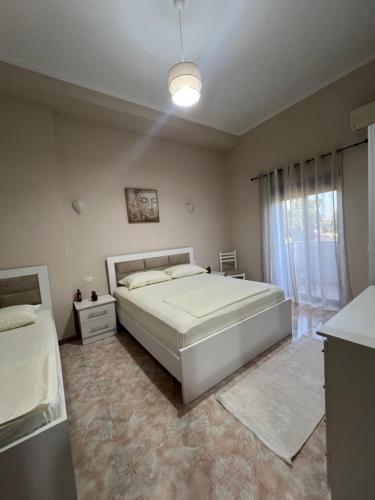 a bedroom with a large white bed and a window at Dyrrah G In the heart of Durres in Durrës
