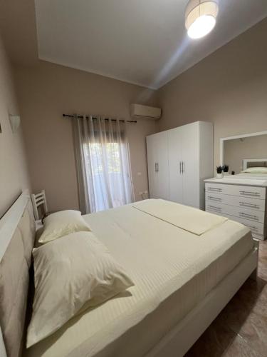 a bedroom with a large bed and a white dresser at Dyrrah G In the heart of Durres in Durrës