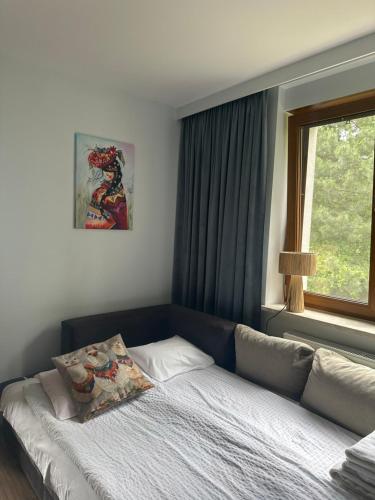 a bed sitting in a room with a window at Świat Jezior in Mikołajki
