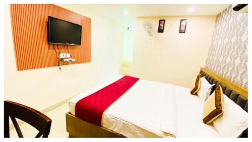 a bedroom with a bed and a tv on a wall at Hotel Ru-pam Tower Patna AC or Non Ac Room in Patna