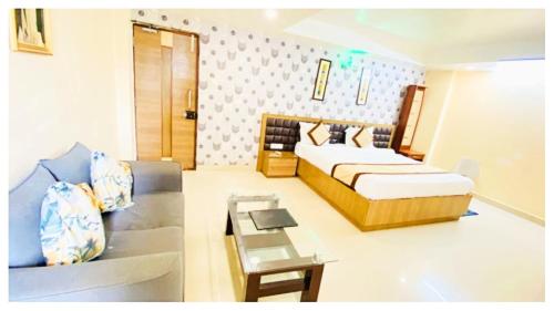 a bedroom with a bed and a couch in it at Hotel Ru-pam Tower Patna AC or Non Ac Room in Patna