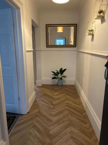a hallway with a mirror and a potted plant at Contractor and Family Cozy Home Sleeps 7 Free Parking in Grimsby