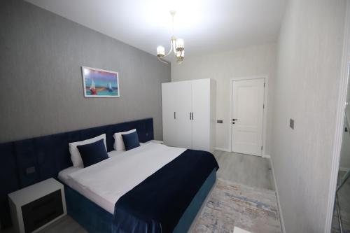 a bedroom with a bed with blue and white sheets at Prime Boutique Hotel in Baku