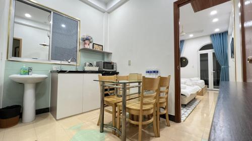 ホーチミン・シティにあるCô Châu Homestayのキッチン(テーブル、椅子付)、バスルーム
