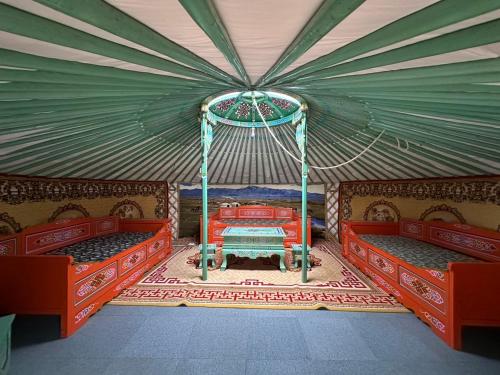 a room with two beds and a table in a tent at モンゴリアンテーマパークジャパン in Kamigō