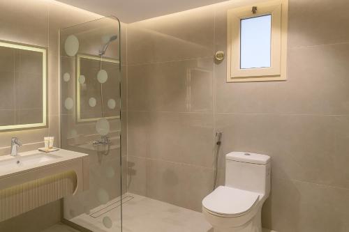a bathroom with a toilet and a sink and a shower at Elite Served Apartments - Al Cornich in Jeddah