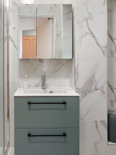 a bathroom with a sink and a white cabinet at Quiet and bright apartment with separate bedroom in Nice