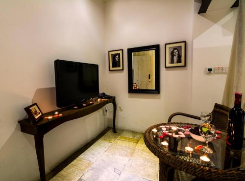 a living room with a tv and a table with candles at Anastou's Traditional House in Kalopanayiotis
