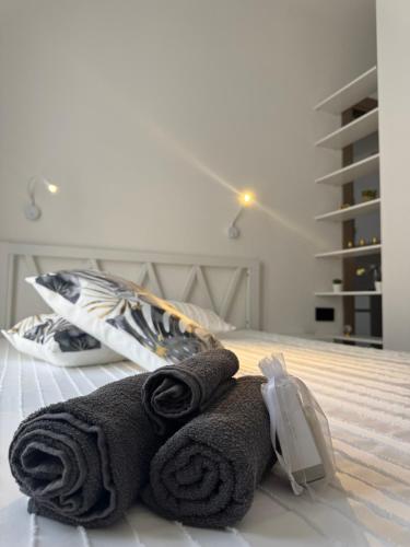 a pair of towels sitting on top of a bed at Domus Aura Apartments in SantʼAntìoco