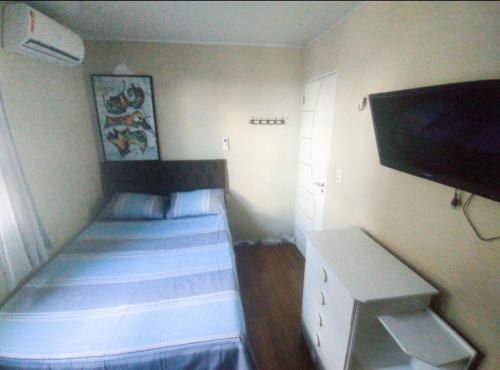 a small room with two beds and a flat screen tv at Residencial Privê Sol Tropical in Belém