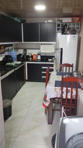 a kitchen with a table and a refrigerator at Residencial Privê Sol Tropical in Belém
