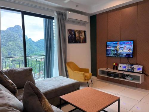 a living room with a couch and a flat screen tv at Theme Park Ipoh - Onsen Premier Suites By MICASA GROUP in Ipoh