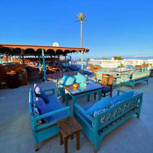 a group of blue tables and chairs on the beach at Ghazala Oasis Hotel in Dahab