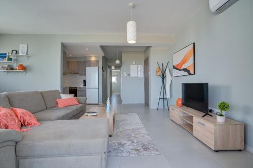 a living room with a couch and a tv at Majestic Sunset Salt Lake Views 300m From Beach in Larnaka