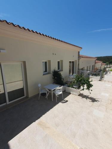a patio with a table and chairs in front of a house at Hotel Borgo Dell'Orso in Palau