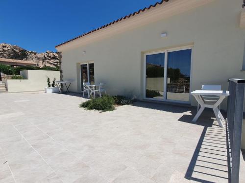 a patio with a table and chairs next to a house at Hotel Borgo Dell'Orso in Palau