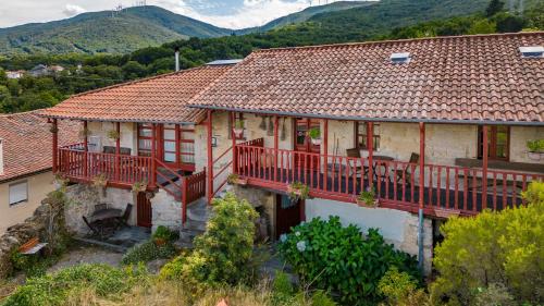 an old house with a balcony and mountains in the background at A Casa da Eira in Cerreda